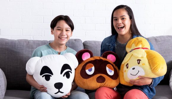 Club Mochi-Mochi- Animal Crossing giveaway: two children sit on a sofa holding a large amount of Animal Crossing themed plushies