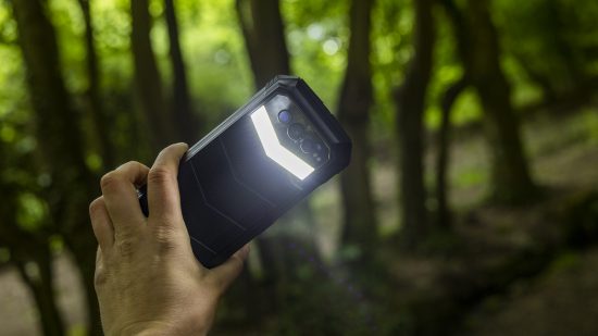 The Doogee S100 Pro torch being tested in a wood