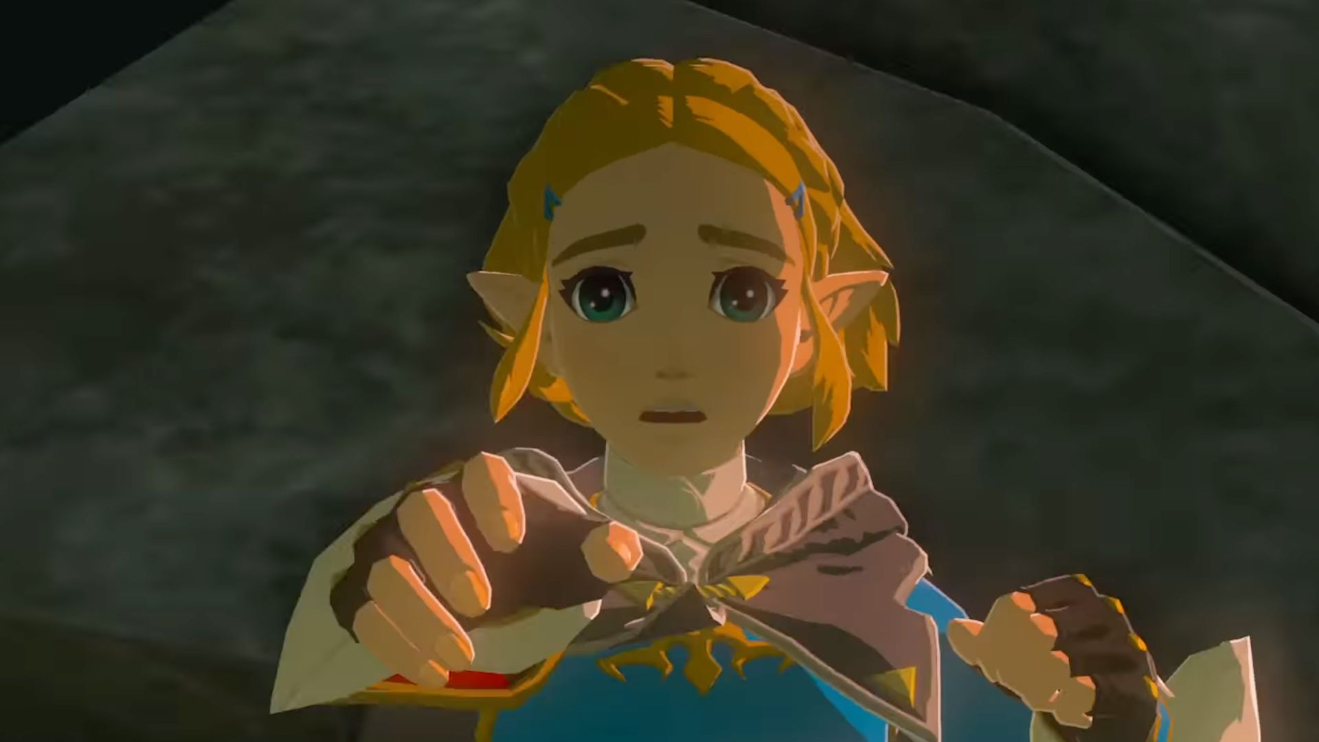 Zelda Tears of the Kingdom review - Link, a blonde boy in a blue tunic, leaping through the air and falling rocks reaching out his hand to Zelda, a blonde woman in a blue tunic and black gown. The shot is a closeup on Zelda's face.