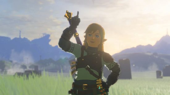 Broń Zelda: Tears of the Kingdom — Link, blondyn w białej tunice, unoszący palec w górę i wyglądający jowialnie w sielankowej scenie pól trawiastych i odległych gór.