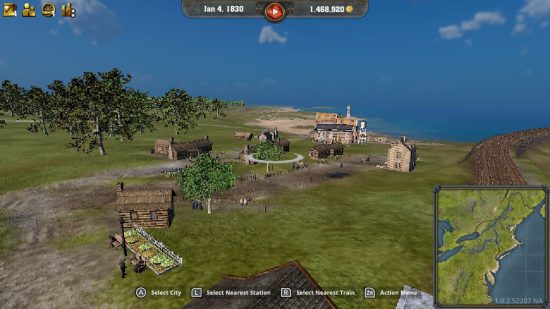 Railway Empire 2 Switch review -- grassy land and a few wooden houses by the sea with trees dotted around