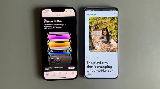 iPhone vs Android header showing an iPhone 14 in black and a Samsung Galaxy S23 in lavender. On the left, the iPhone is on the Apple Store page showing a marketing shot for the Apple iPhone 14 Pro, on the right the Samsung is on the Android website showing a woman using a phone.