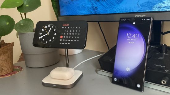 iPhone vs. Samsung: which is better for gaming? header image showing two phones, the iPhone 13 and the Samsung S23 Ultra. They're both black, showing their screens, with a clock and calendar on the iPhone in landscape on a stand, the samsung in portrait with the Lock Screen showing.