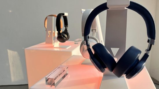 a JBL headset sat on a clear stand with a pink table below