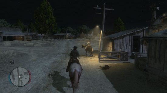 Read Dead Redemption Switch review screenshot showing a man riding a horse by a lamplight illuminating a woman riding a horse. It's night, and they ride on a dirt track next to a small building.