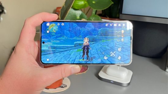 Samsung Galaxy S23 review shot showing the Samsung Galaxy S23, in Lavender, showing its screen in landscape playing genshin impact.