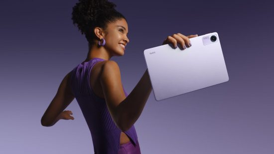Xiaomi Redmi Pad SE header showing a woman in a purple dress with dark hair in a side on profile, both arms outstretched to either side of herself. In the arm nearest us is a tablet in purple, all on a purple gradient background.