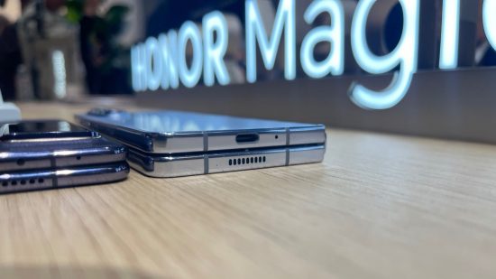 Nagłówek Best of IFA 2023 przedstawiający Honor Magic V2 zamknięty i leżący na stole obok grubszego składanego telefonu Samsung przed podświetlonym logo telefonu.