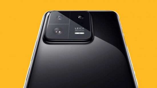 Xiaomi 14 Pro header showing a 13 Pro in black on a mango yellow background. It's got a black glass back and square camera bump also in black.
