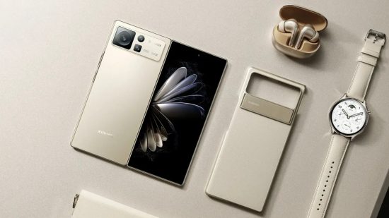 Xiaomi Mix Flip header showing a folding phone unfolded in white on a beige desk next to a phone case, earbuds in a case, and a watch, all the same colour.