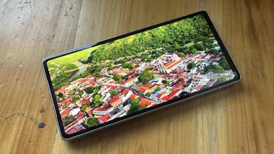 Picutre of the display on the Google Pixel 7a with colorful houses and green trees for a review of the phone