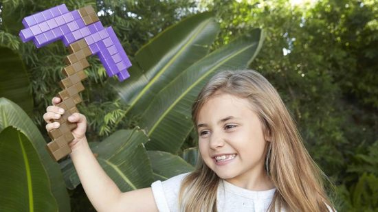 best Minecraft toys - A young girl waving a Plastic Minecraft pickaxe replica in a garden