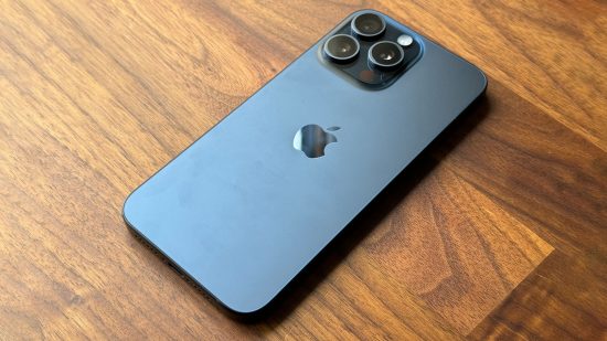 Best gaming phones - the iPhone 15 Pro Max laying screen-down on a wooden table