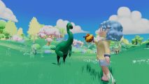 Paleo Pines Switch review: A light-blue-haired player character in a yellow jacket offering a brown treat to a deep green Gallimimus in a green field