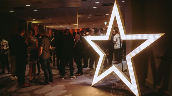 Develop:Star Awards - a star-shaped light in a room of people