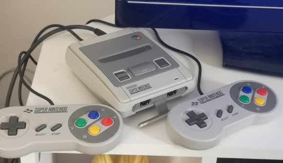 Super NES Classic Edition review image showing the console and its controllers beside a TV.