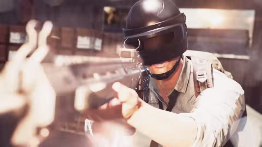 a soldier wearing a helmet similar to a welding visor, is looking down the sights of a futuristic gun