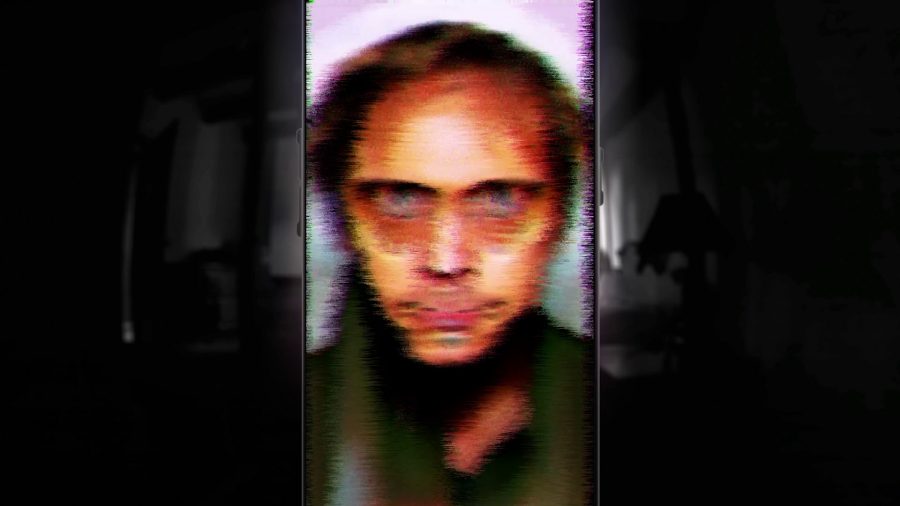 A blurry figure seen through a phone screen