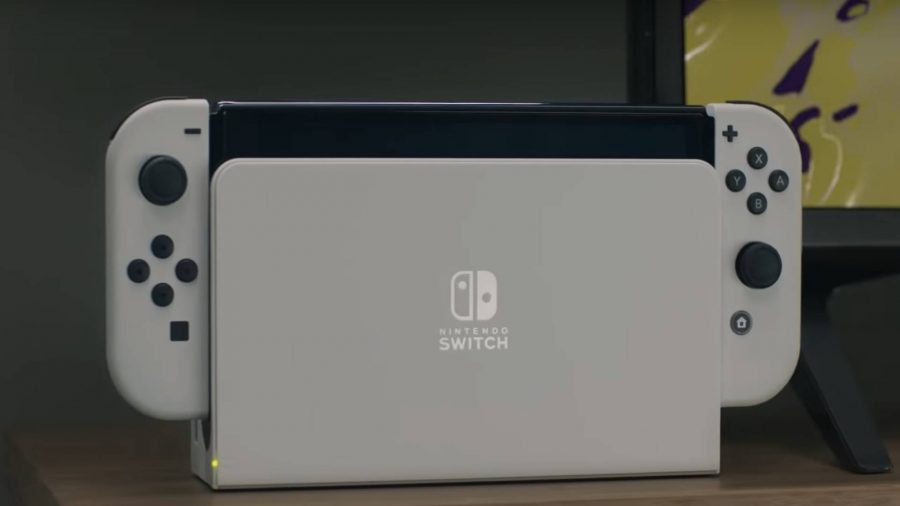 The white Nintendo Switch OLED Model is displayed on a TV stand