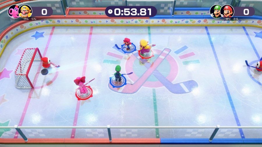 Several character from Super Mario are embroiled in a game of hockey, on a large, brightly coloured ice rink