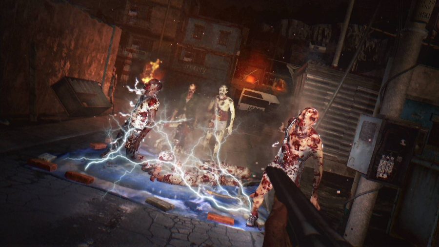 A series of zombies appear in front of a shotgun, held in first-person by the protagonist. The zombies seem to have stepped on a trap and appear to be getting electrified 