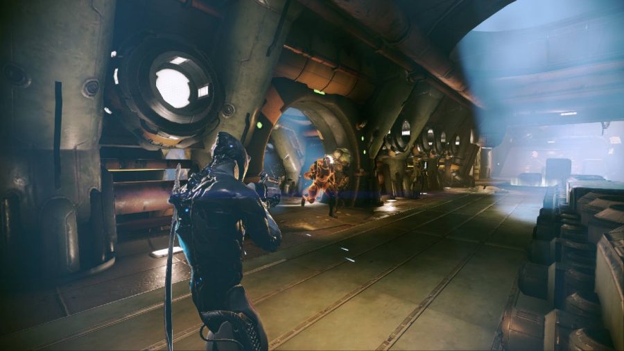A futuristic room shows two people facing each other with weapons, they are both wearing suits designed for combat
