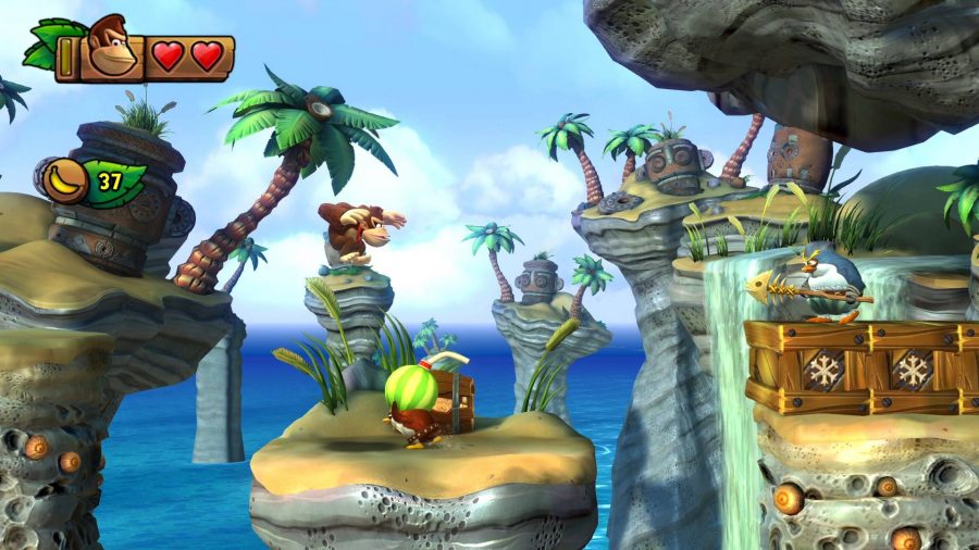 Donkey Kong jumps in the air above an enemy, while a beach and palm trees are visible in the background