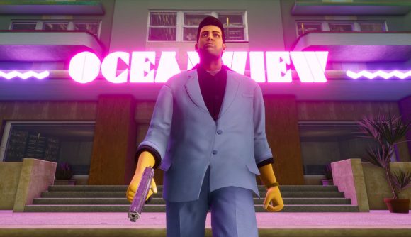 The protagonist from Grand Theft Auto Vice City stands in front of a large neon sign, dressed in an oversized blue suit