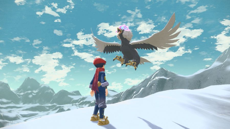 A Pokemon trainer stands on a snowy cliff edge 