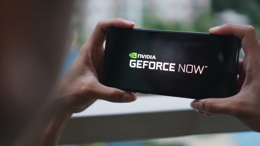 A pair of hands are seen holding a mobile device, with Nvidia Geforce Now and it's logo clearly visible on the screen