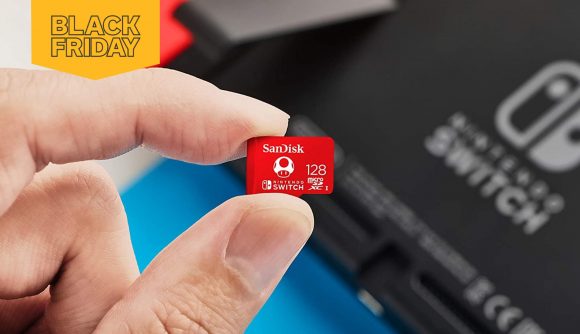 A hand holds a 128GB SanDisk microSDXC card. A Nintendo Switch is in the background.
