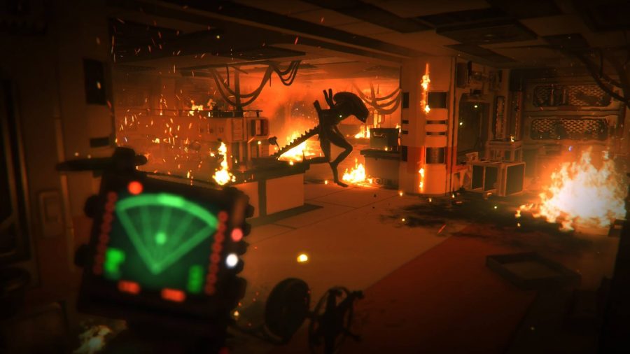 An entire room is on fire with the alien xenomorph walking through the chaos 