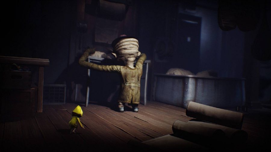 A small child in a yellow jacket crawls to avoid a large headed enemy 