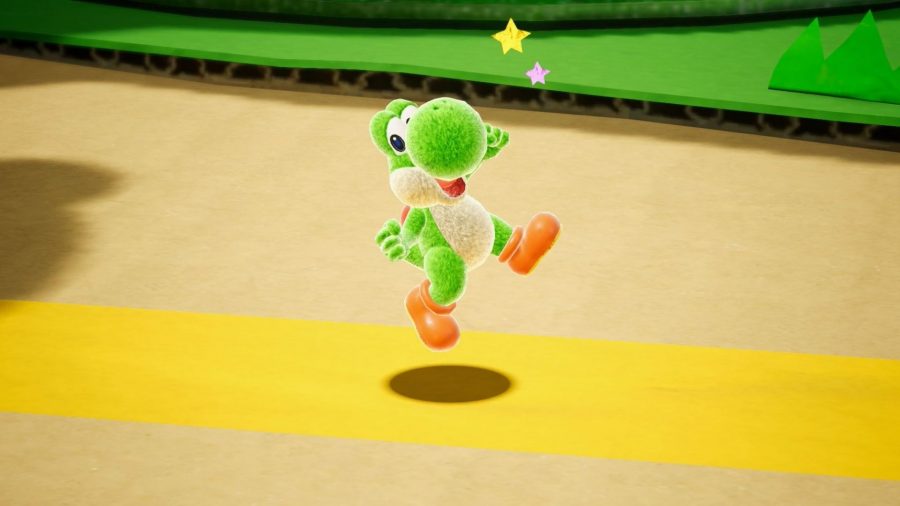 Yoshi, made of yarn, jumping in the air in celebration, from Yoshi's Crafted World.