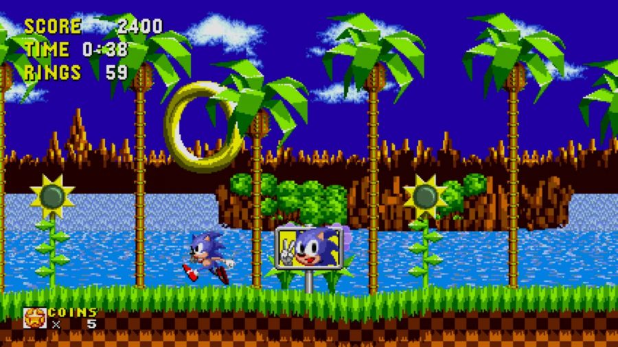 best upcoming switch games: a pixelated scene shows a small blue hedgehog running across a green hill zone 
