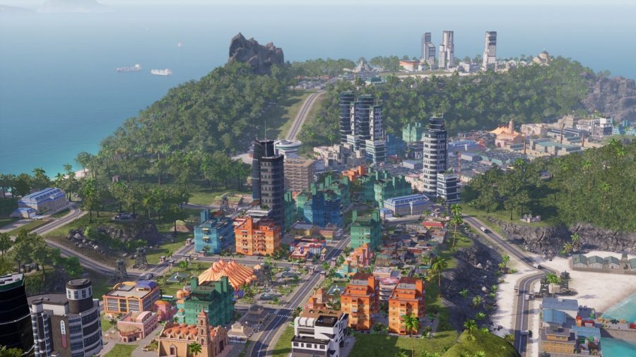 A screenshot from Tropico 6, showing a town by the coast.