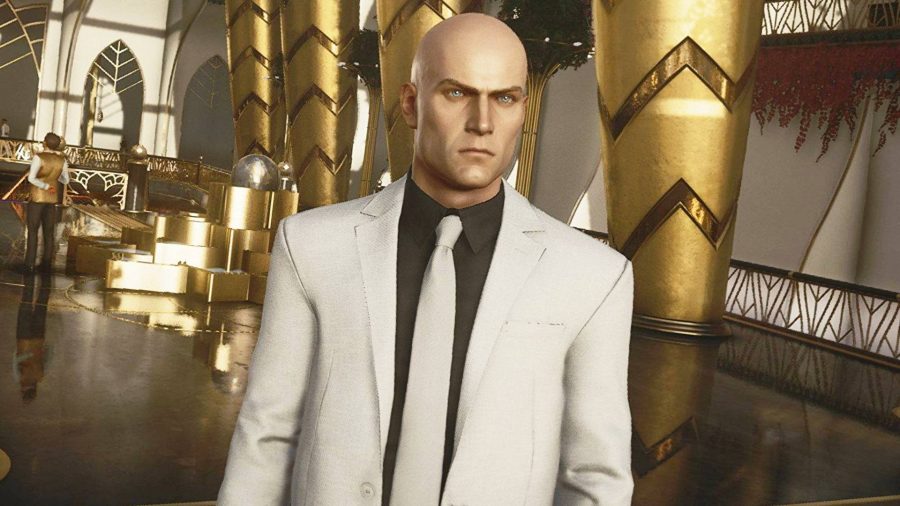 best spy games: Agent 47 from Hitman stands with his huge bald head glowing in a golden room, baldly