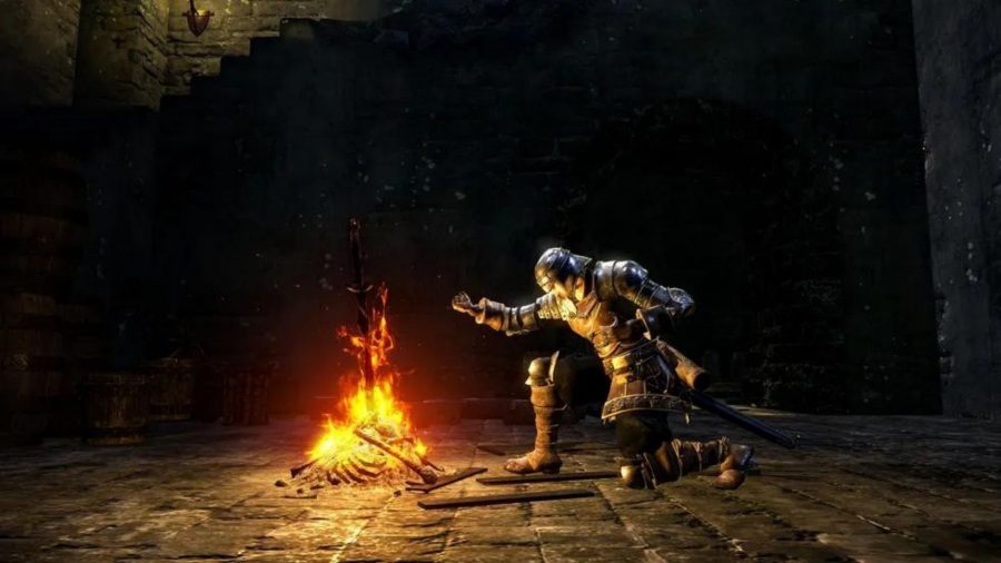 A Dark Souls character kneels with one arm outstretched over a bonfire.