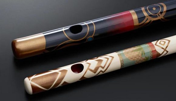 The two Xenoblade Chronicles 3 flutes, custom built for the game. One is black, with red and gold detailing. One is white, with green, red and gold detailing.
