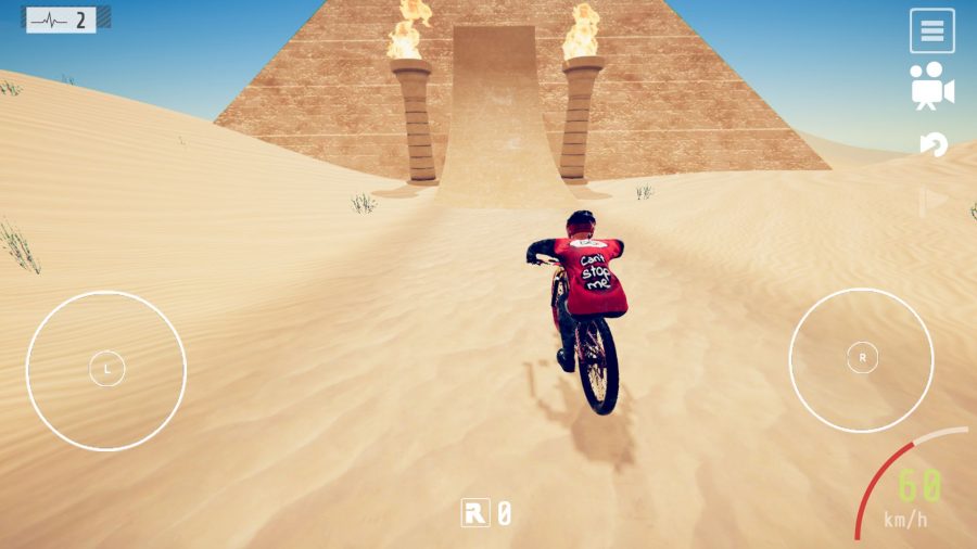 A screenshot from our Descenders mobile review showing a biker riding towards a pyramid along sand, with two pillars with fire atop them either side of the path up the pyramid.