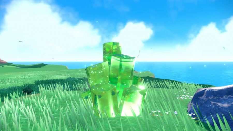 Pokemon Scarlet and Violet tera raid battles: a green crystal is visible on a grassy surface, it is glowing with energy